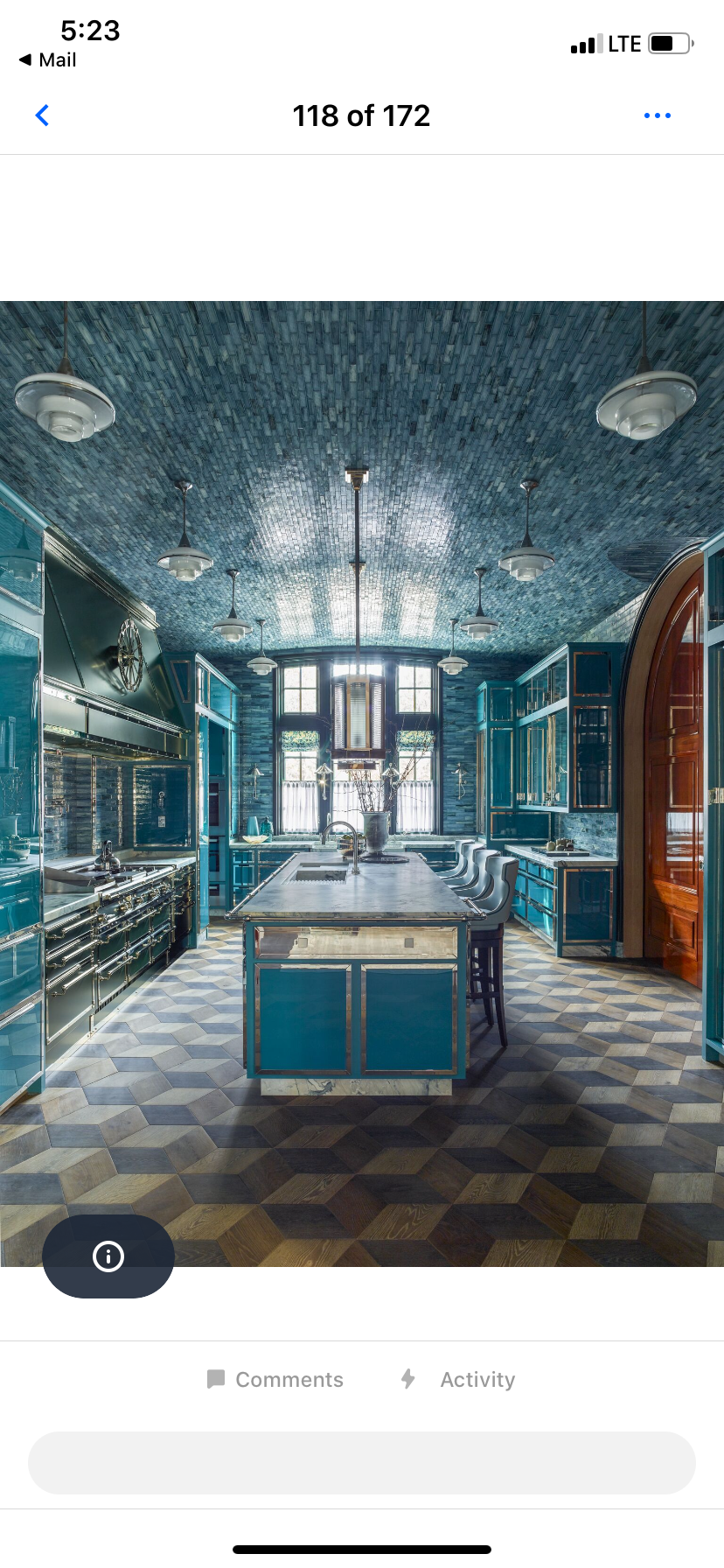 A kitchen with blue cabinets and a large island in the middle.