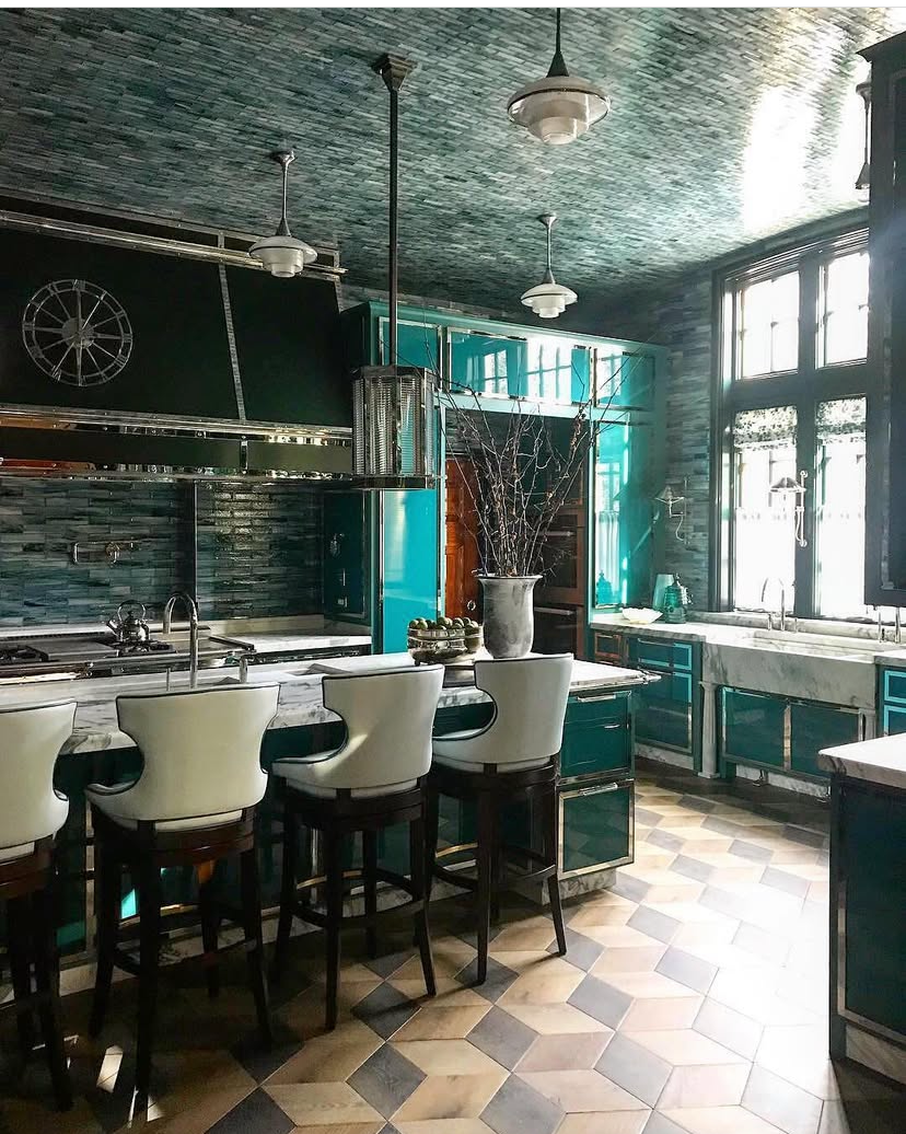 A kitchen with blue cabinets , white chairs , and a checkered floor.