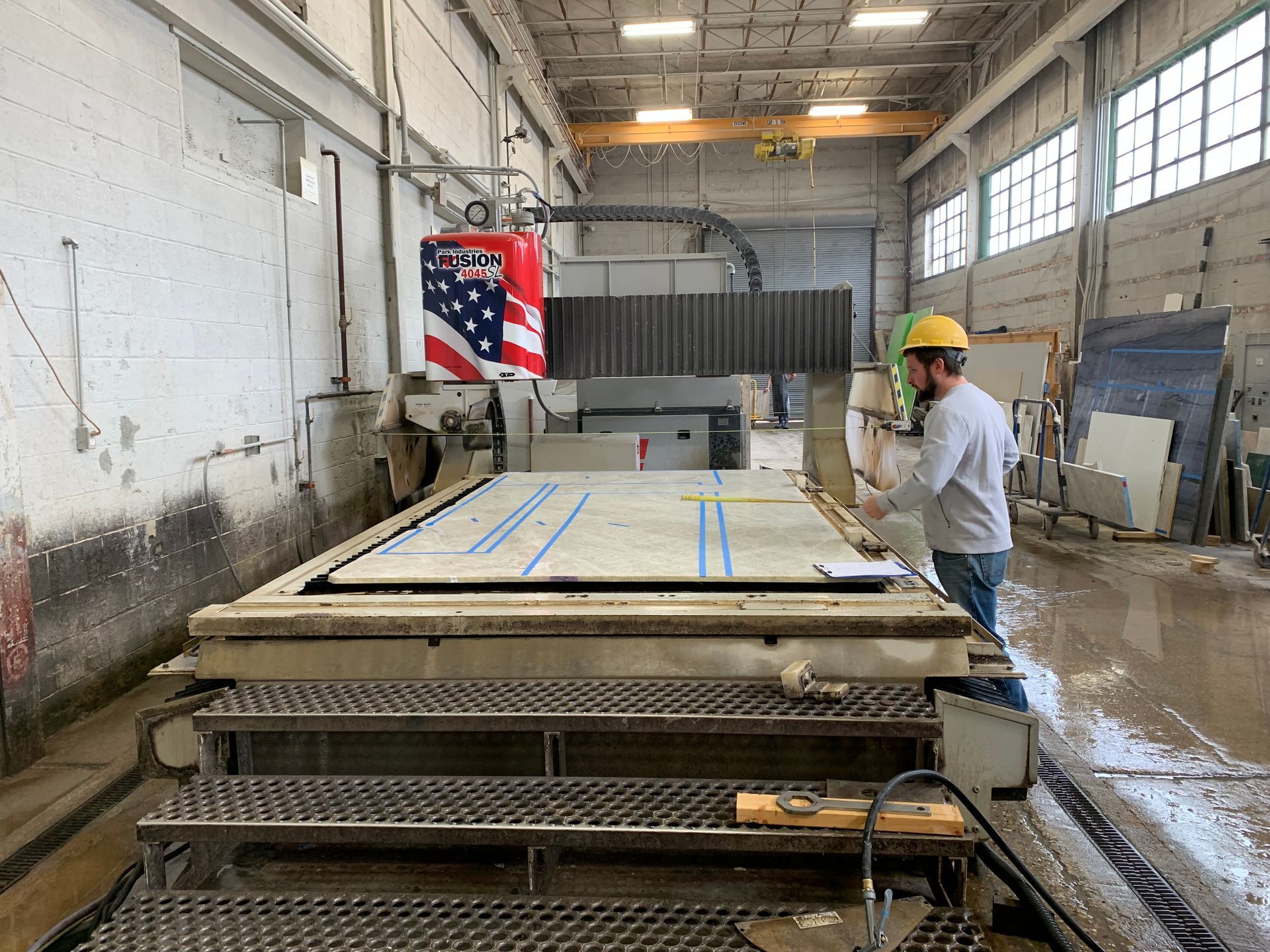 A man is standing in front of a machine in a factory.