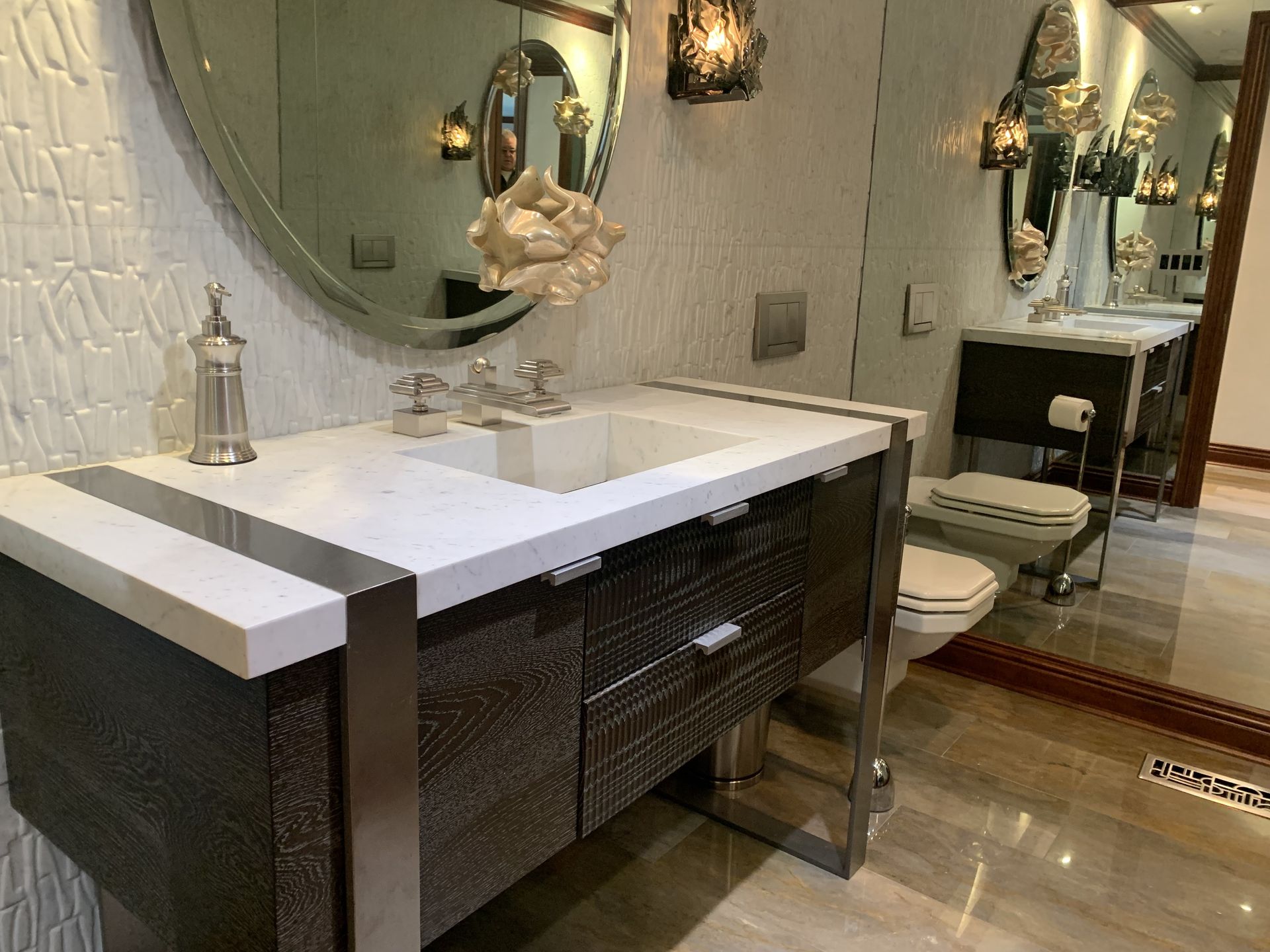 A bathroom with two sinks , a toilet and a mirror.