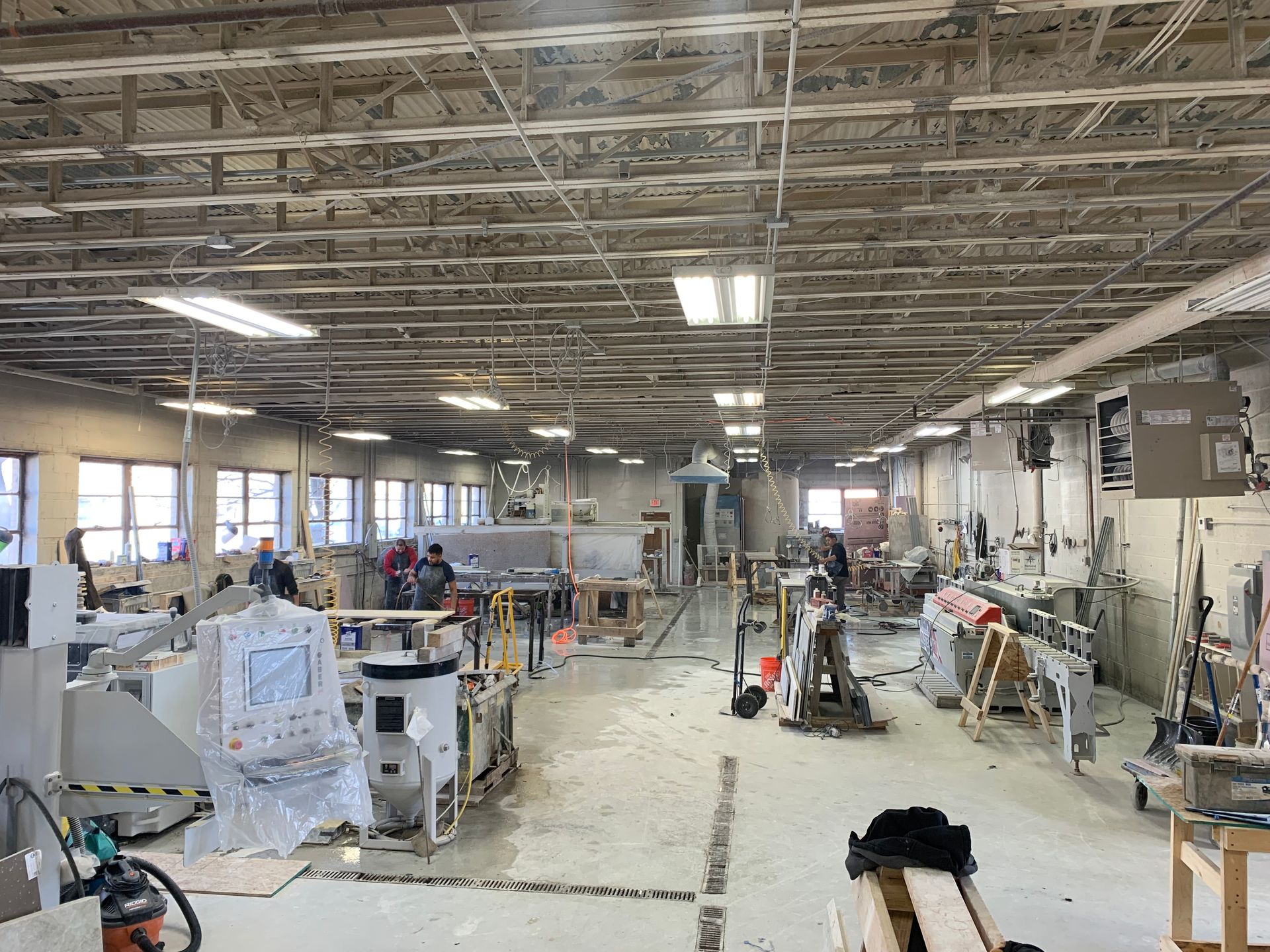 A large warehouse filled with lots of machinery and people.