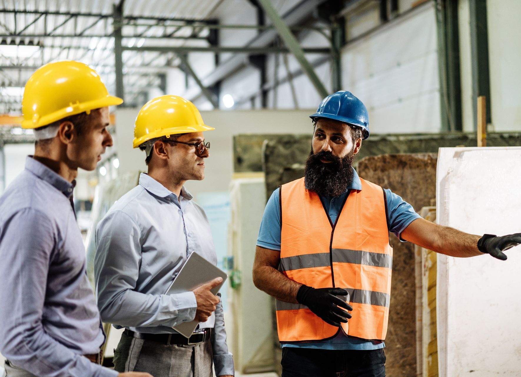 A group of people are sitting around a table looking at blueprints.