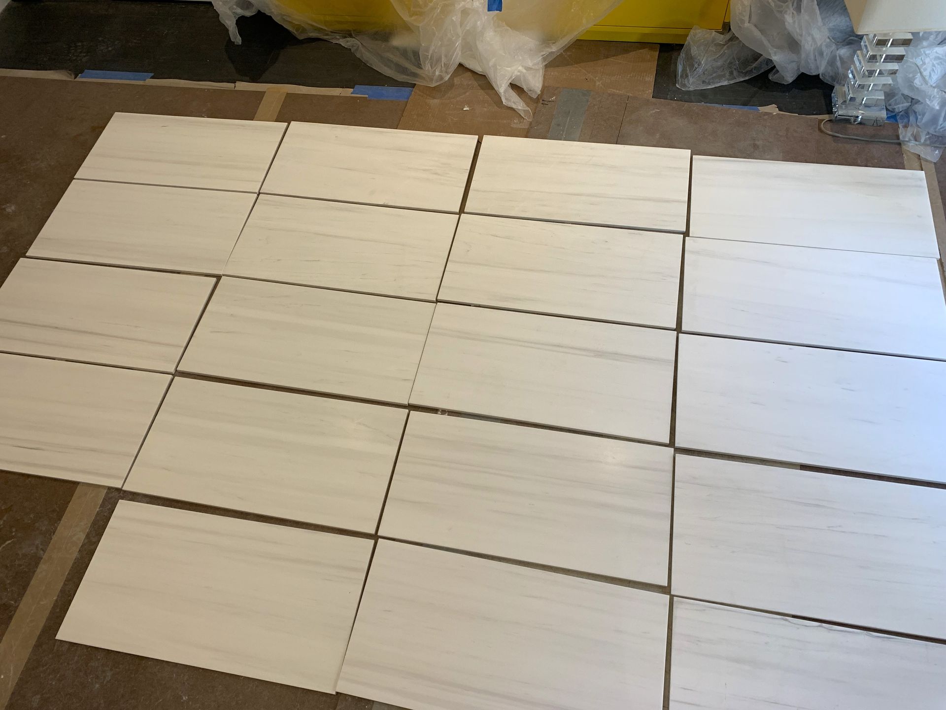 A bunch of white tiles are laying on the floor