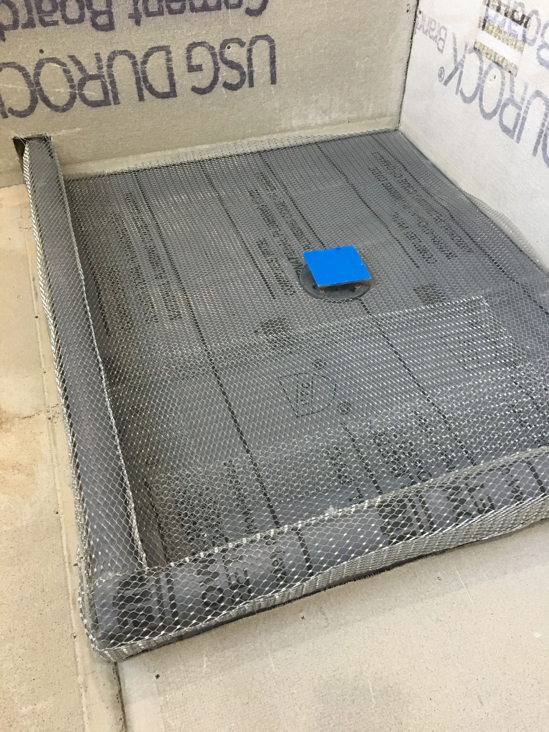 A blue square is sitting on top of a gray surface.