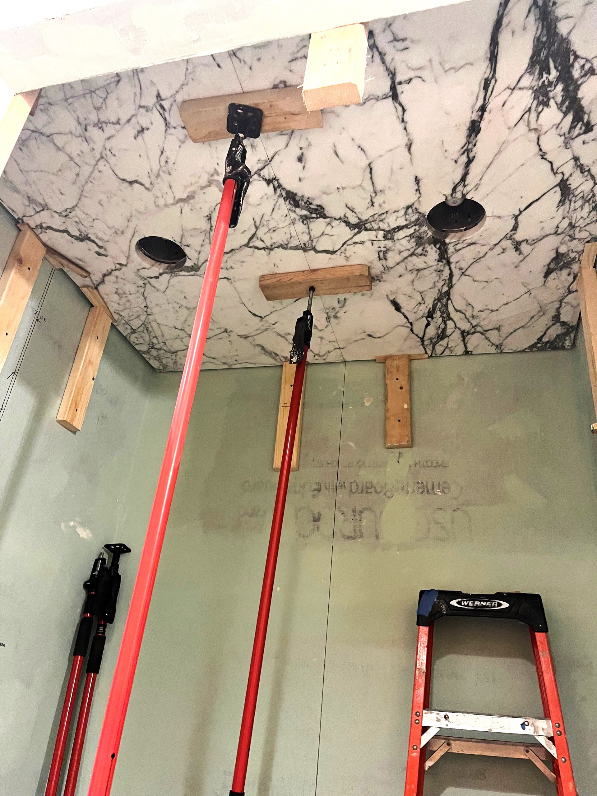 A room with a ladder and a marble ceiling