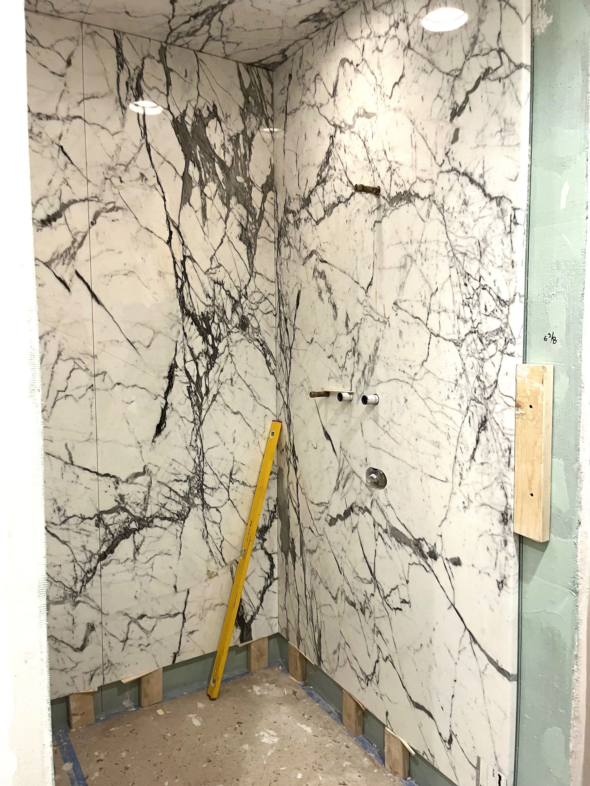 A bathroom with marble walls and a yellow level