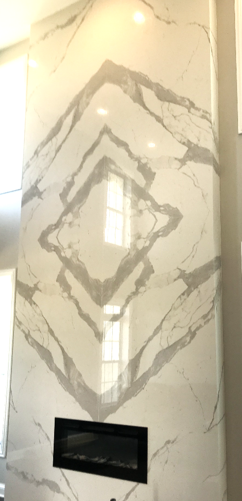A fireplace is sitting in front of a large marble wall.