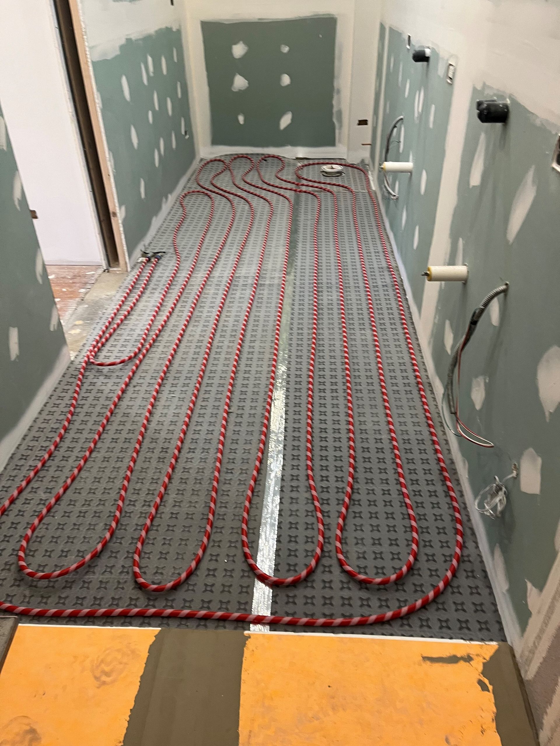 A long hallway with a lot of wires on the floor.