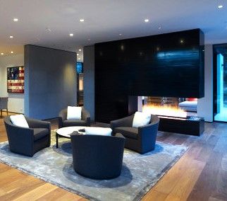 A living room with a fireplace , chairs and a table.