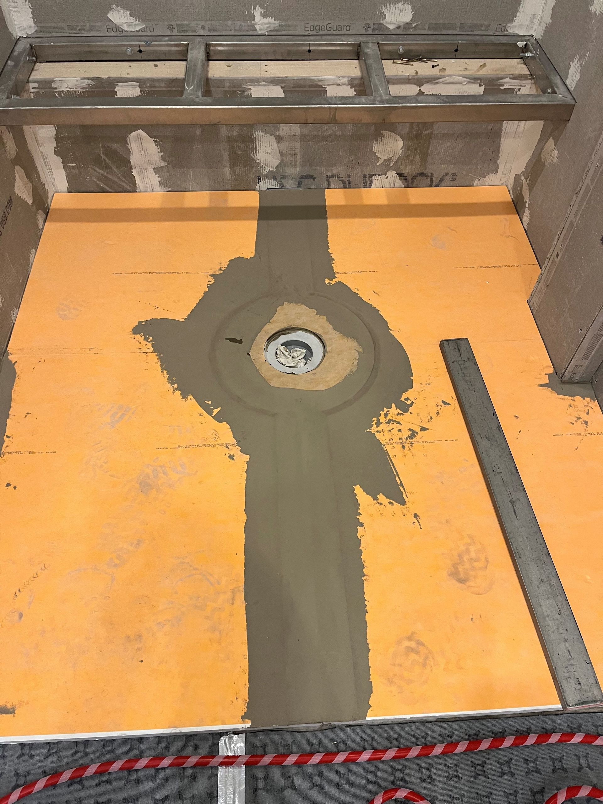 A drain is being installed in a bathroom under construction.