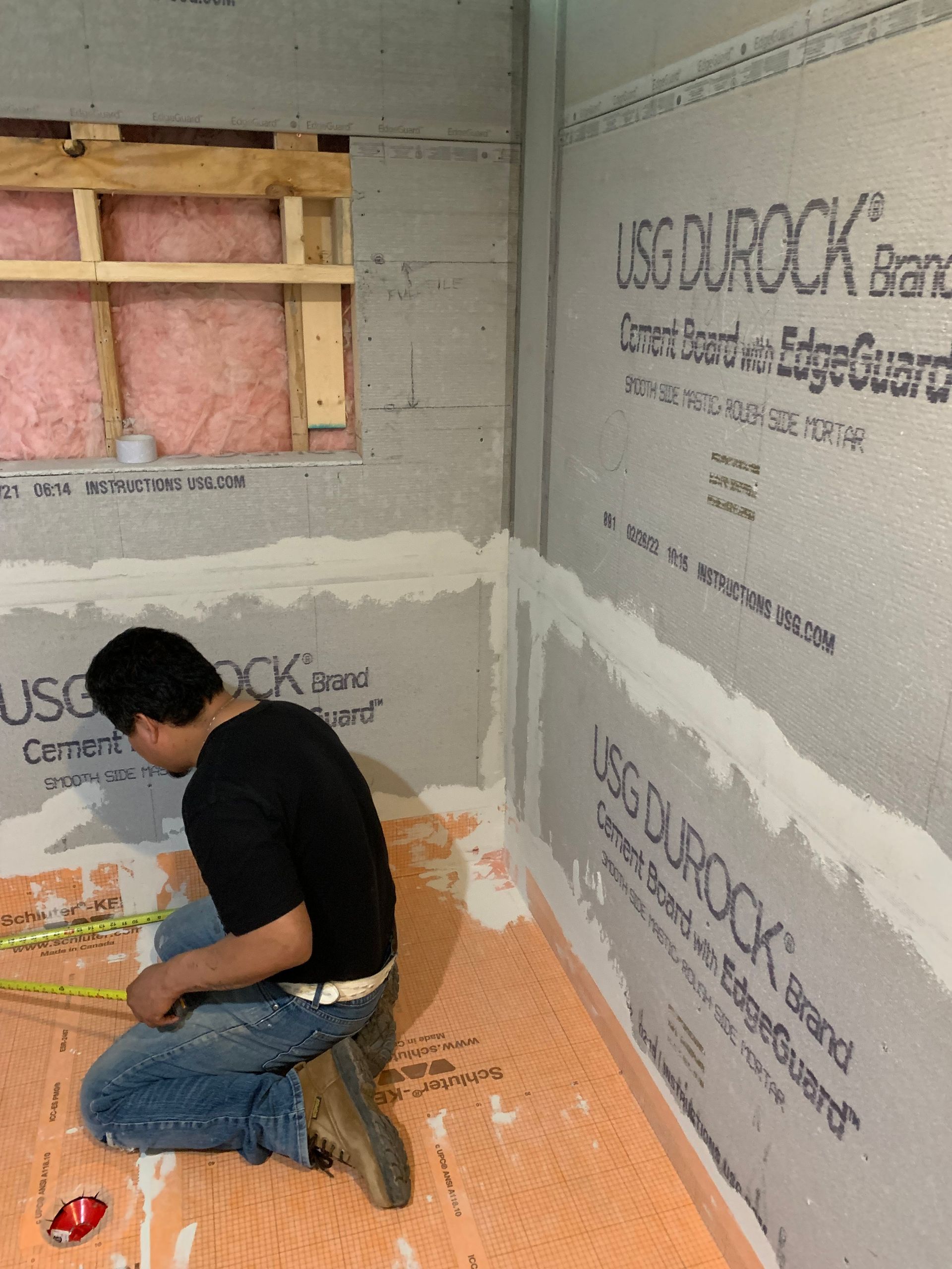 A man kneeling in front of a wall that says usg ourrock
