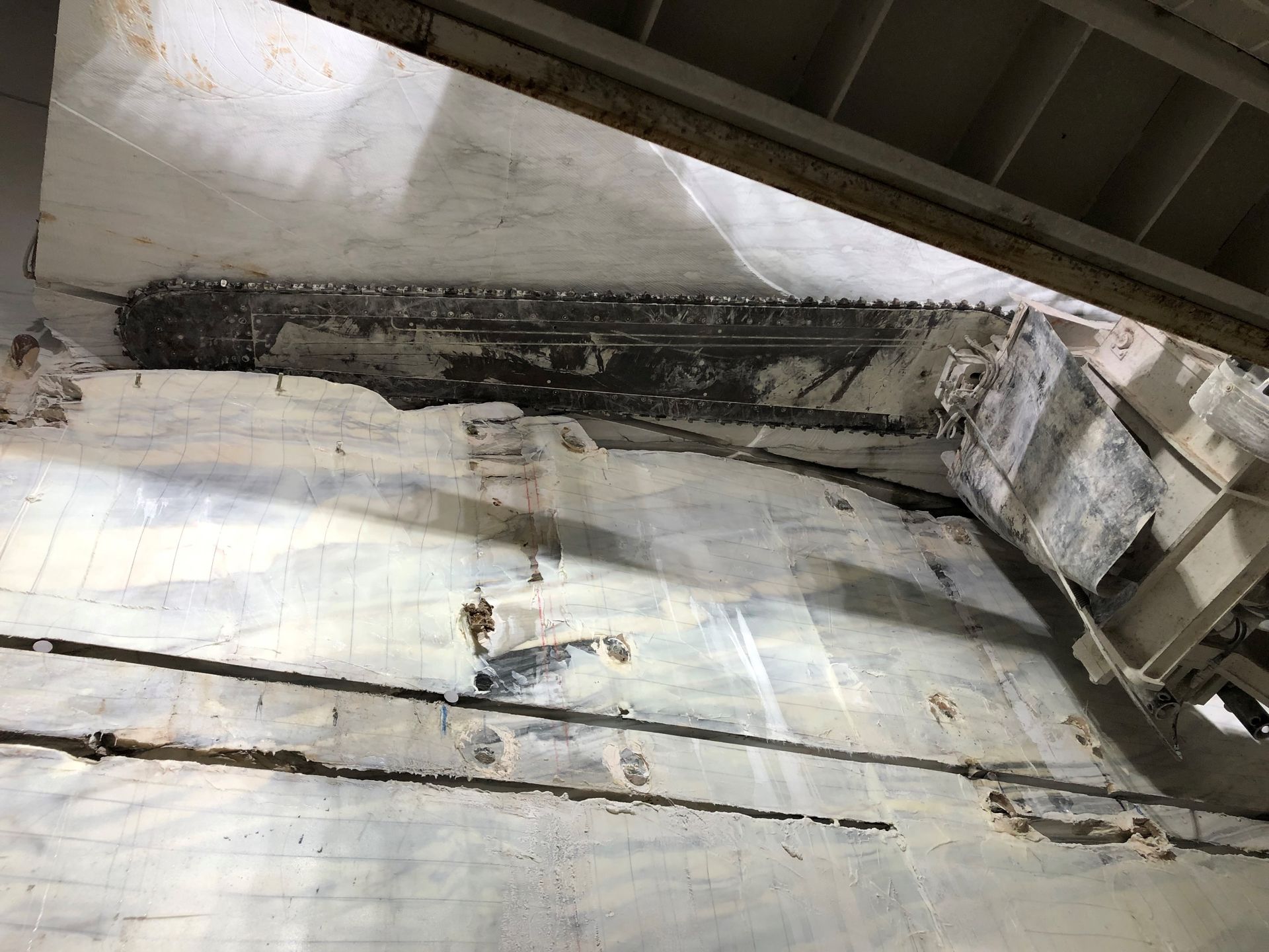 A large piece of marble is being cut into pieces in a marble quarry.