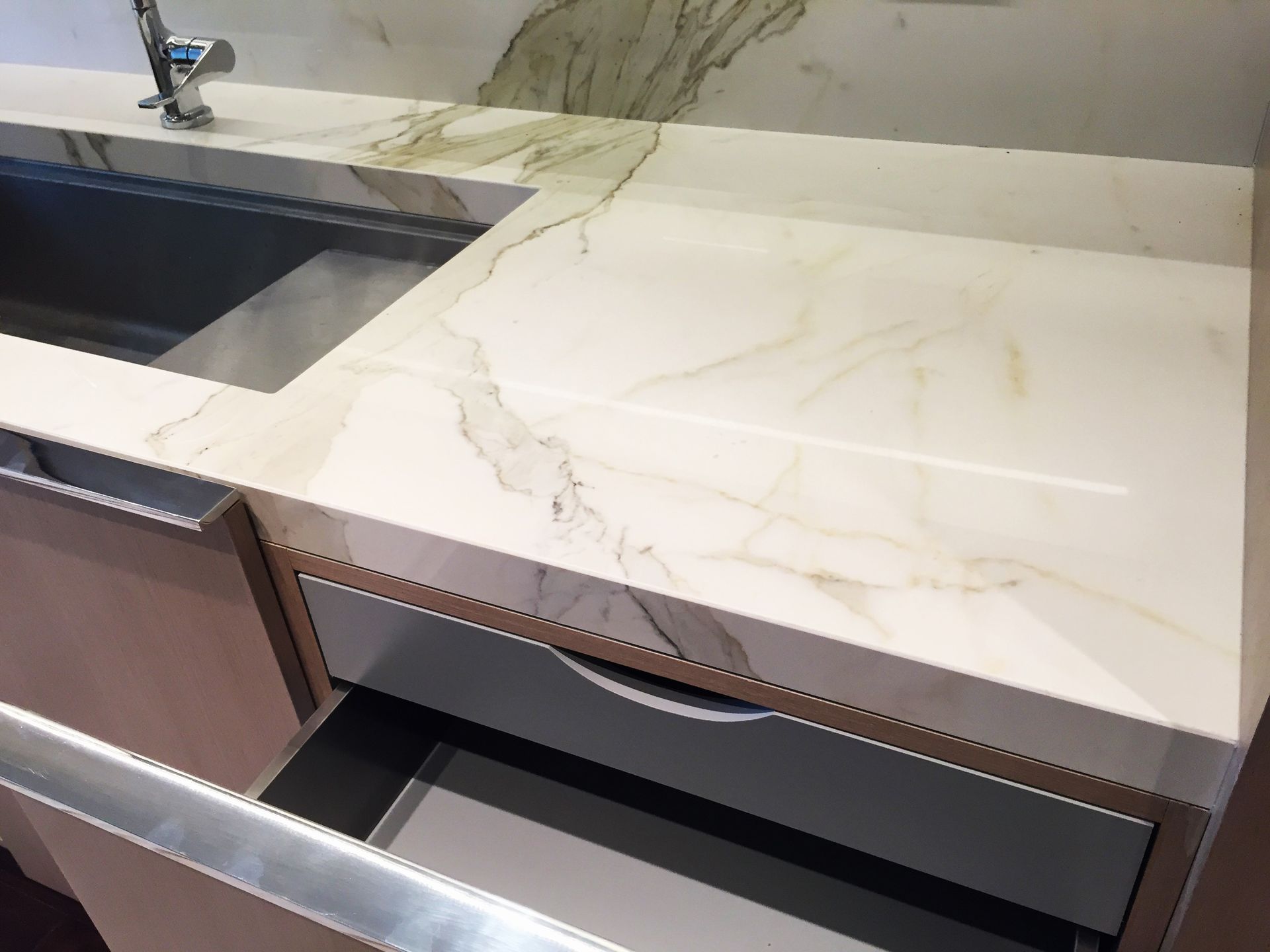 A kitchen counter with a sink and a drawer open