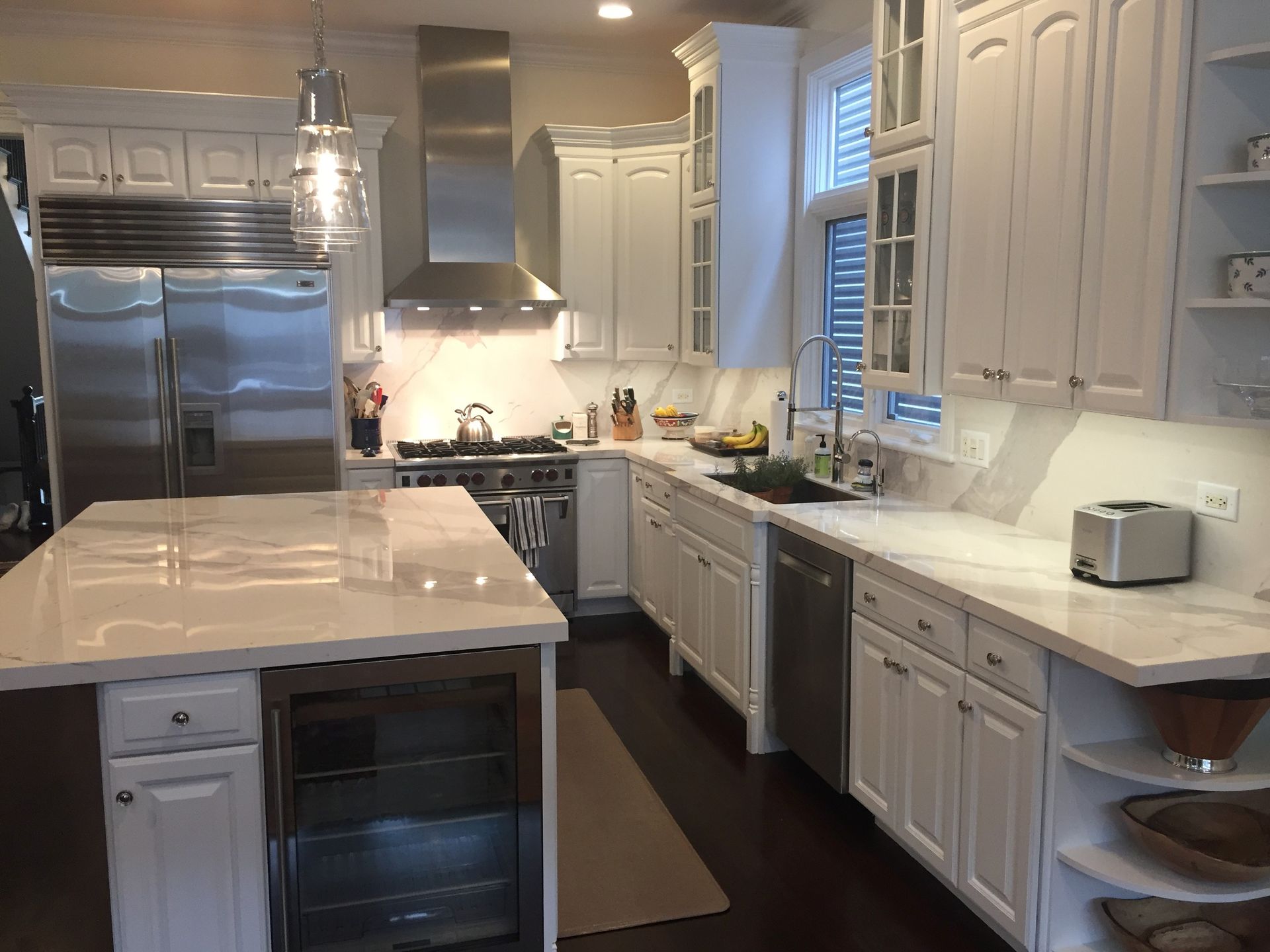 A kitchen with white cabinets and stainless steel appliances