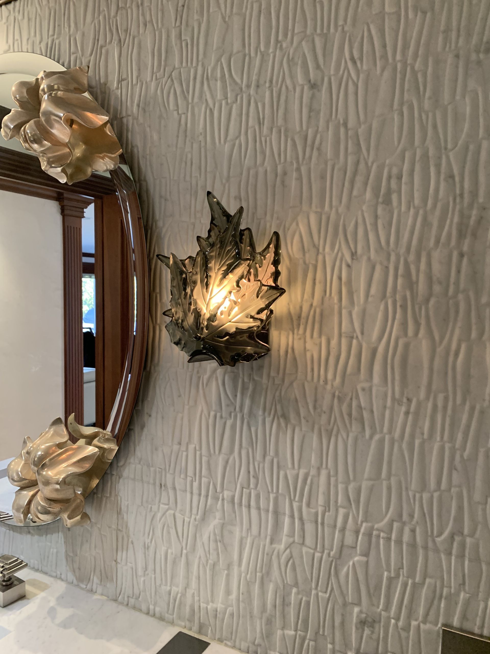 A bathroom with a mirror and a lamp on the wall.