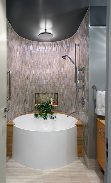 A bathroom with a round tub and a shower.