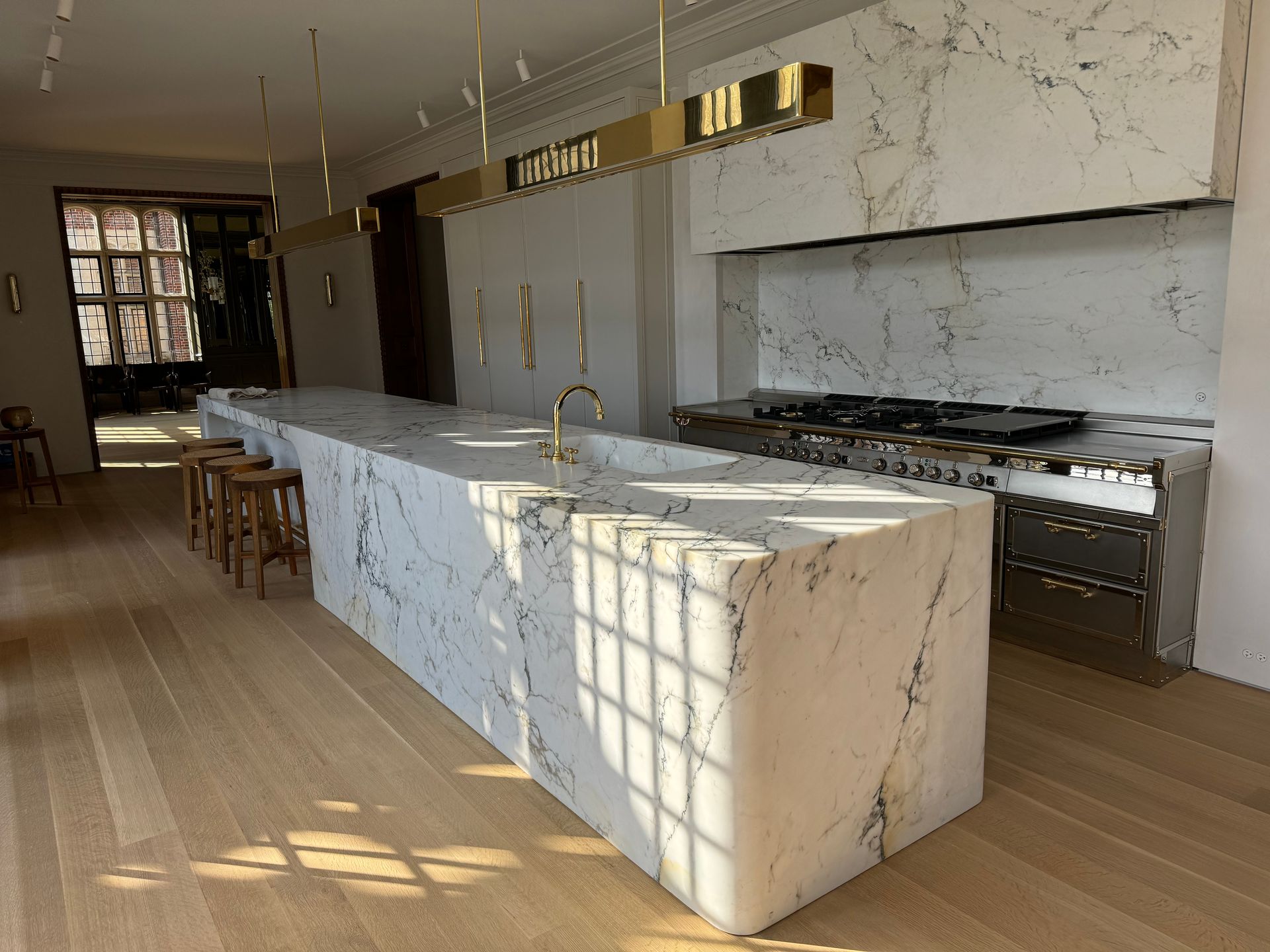 A kitchen with marble counter tops , stainless steel appliances , and wooden floors.