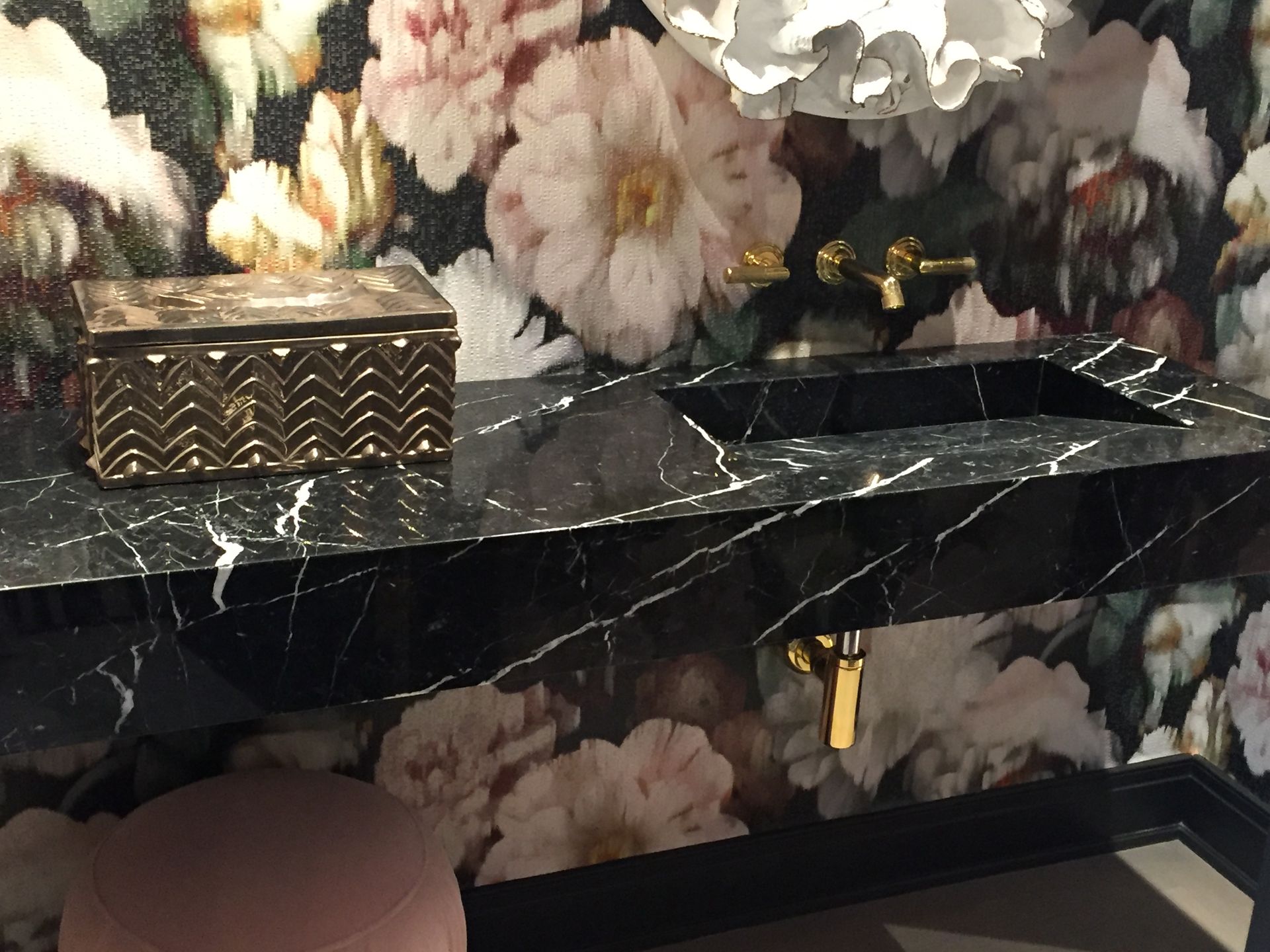 A bathroom with flowers on the wall and a sink