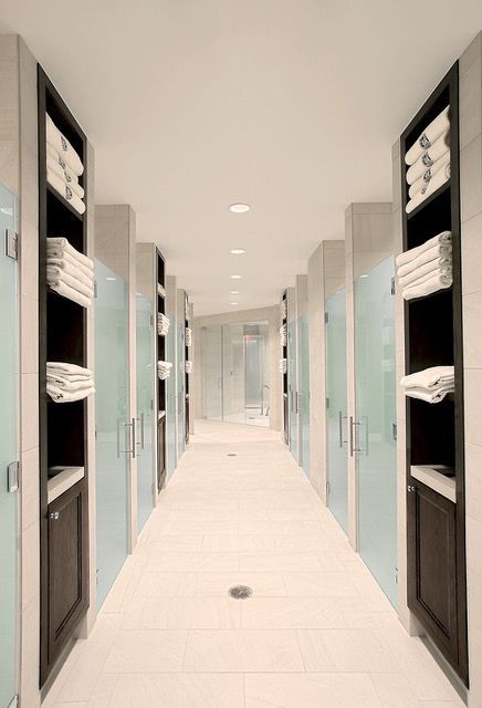 A long hallway with lots of shelves and cabinets filled with towels