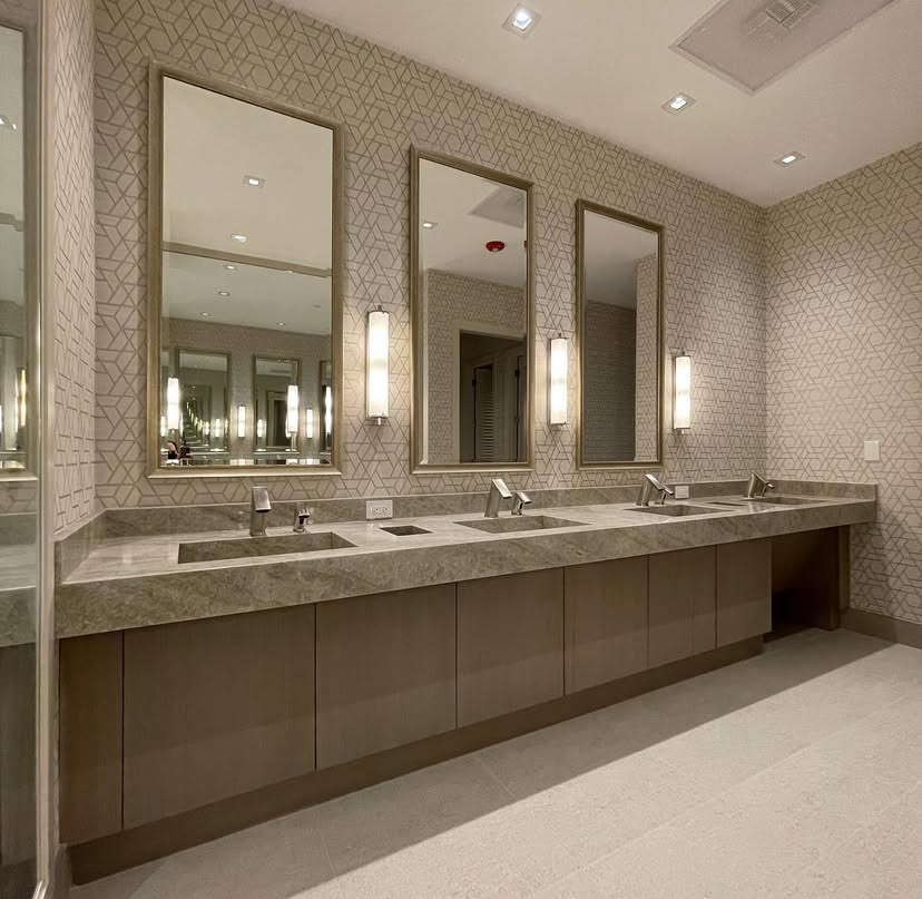 A bathroom with three sinks and three mirrors