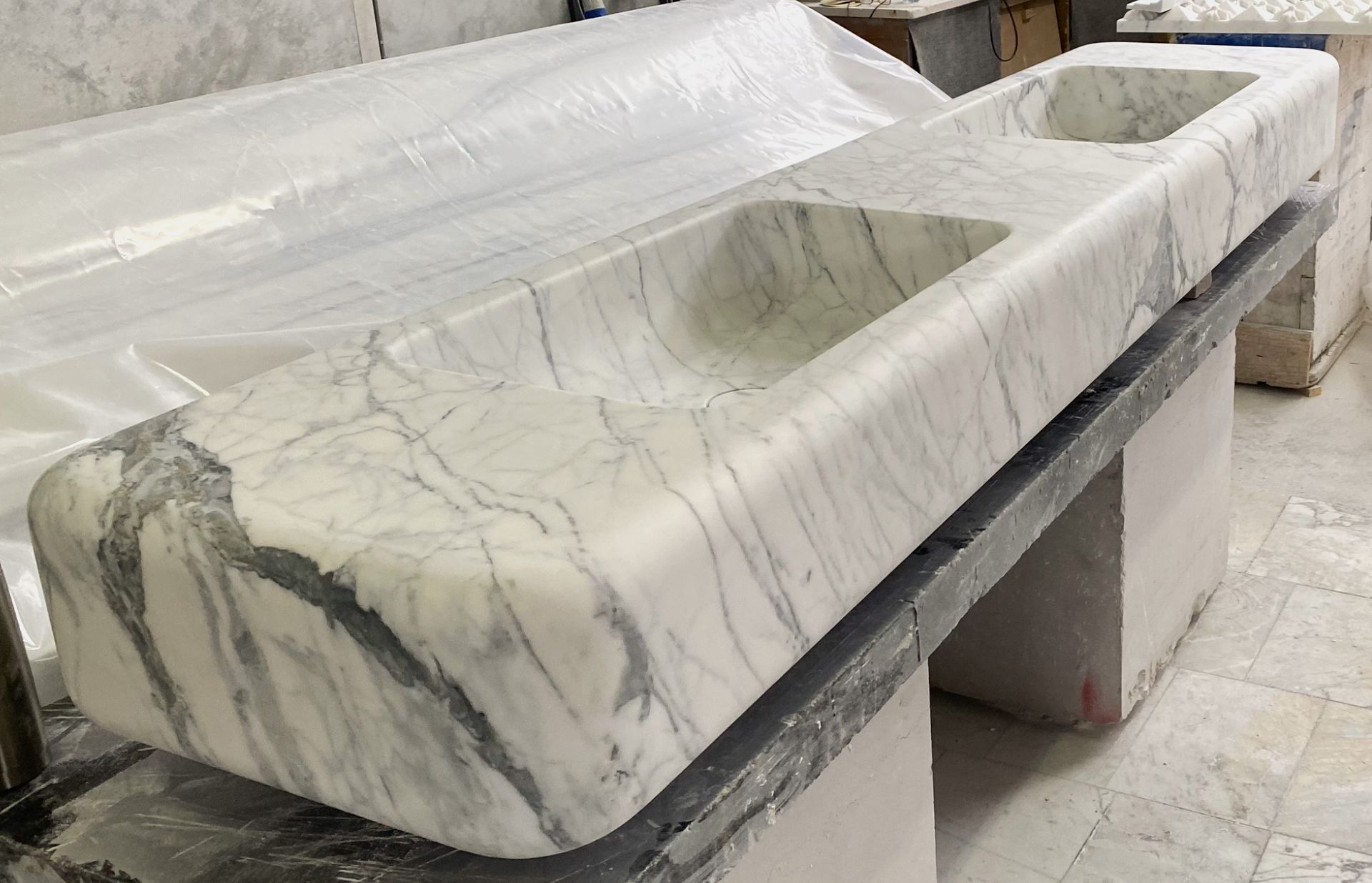 A white marble sink is sitting on top of a table.
