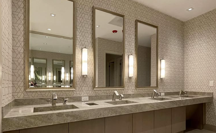 A bathroom with three sinks and three mirrors.