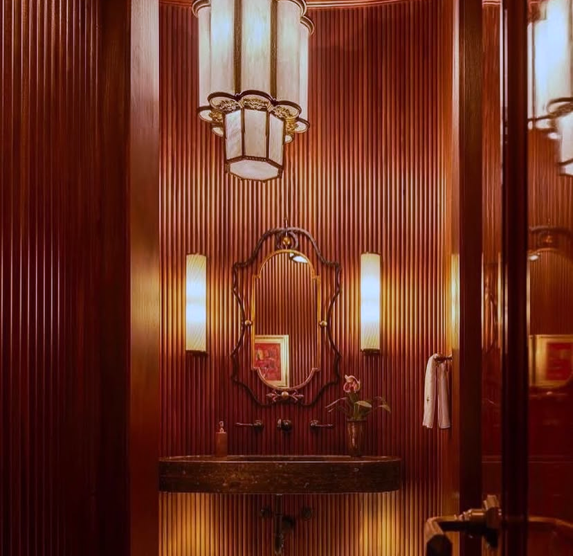A bathroom with a sink and a mirror hanging from the ceiling