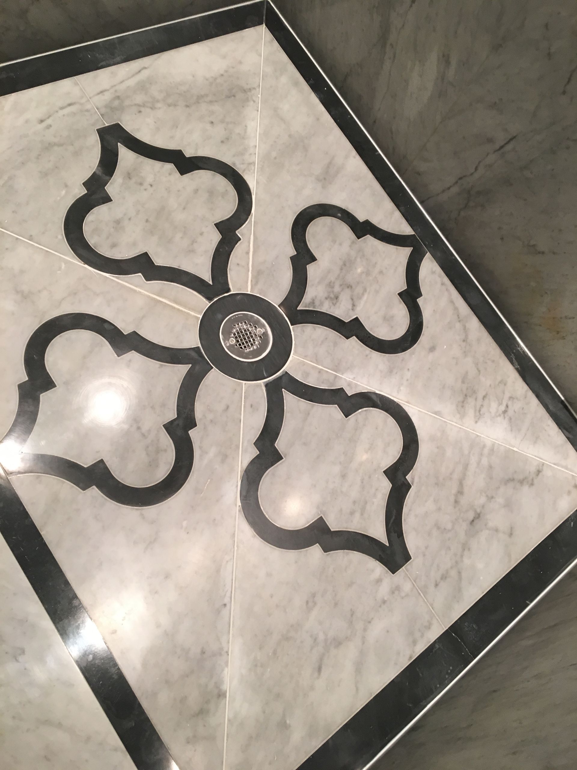 A black and white tile with a flower design on it