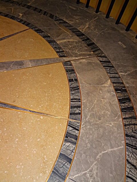A close up of a compass on a tiled floor