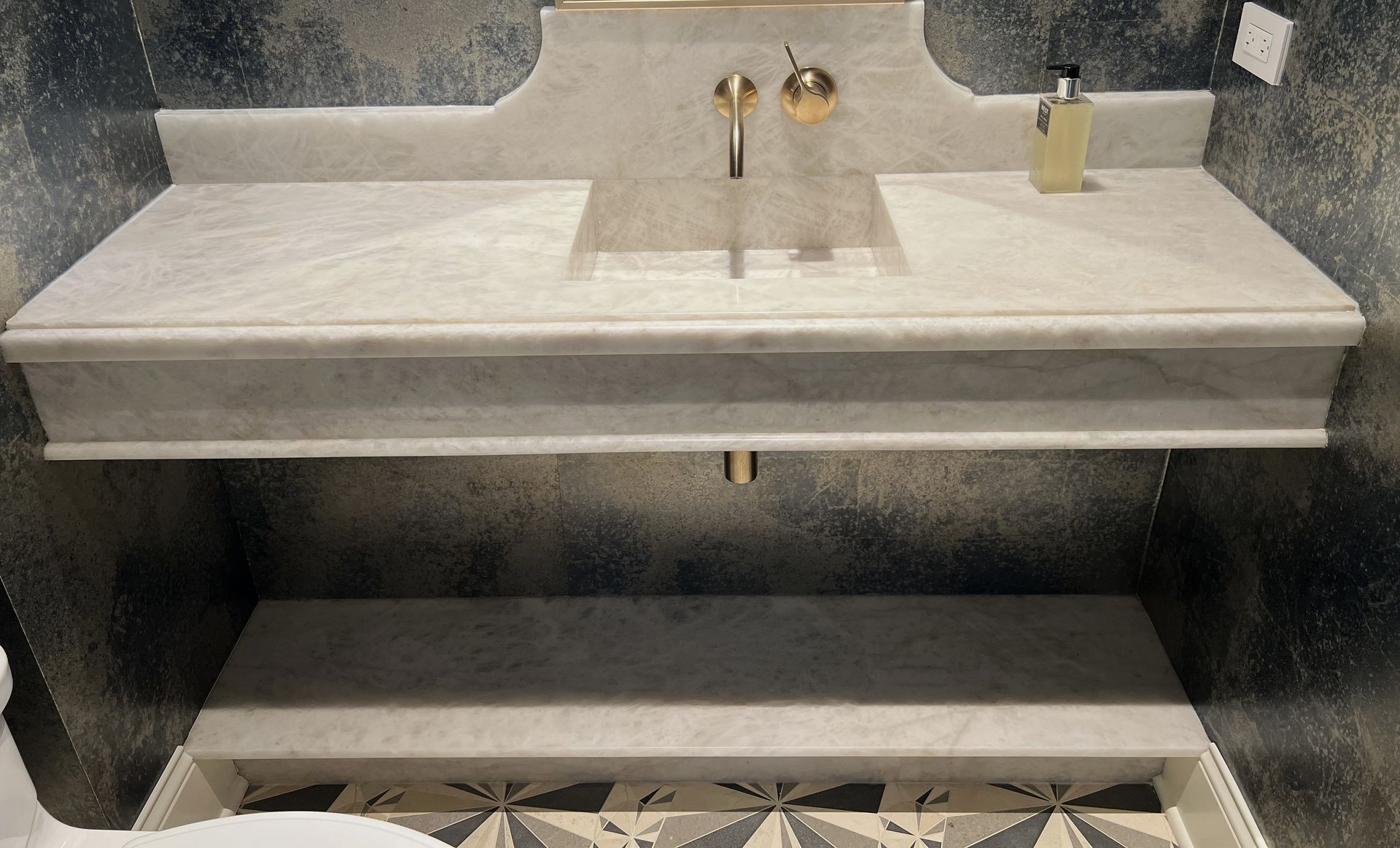 A bathroom with a sink and a soap dispenser