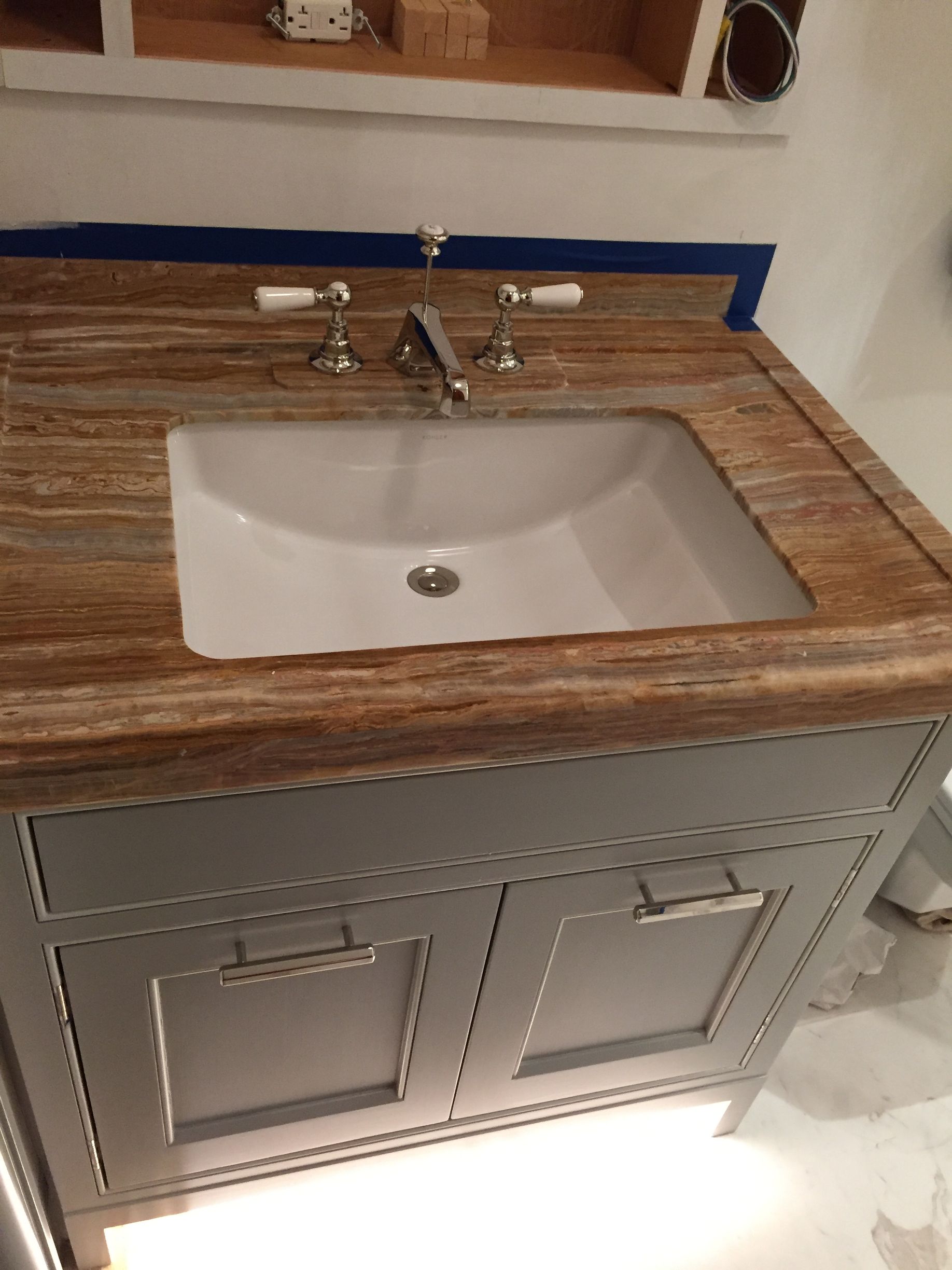 A bathroom sink with a wooden counter top