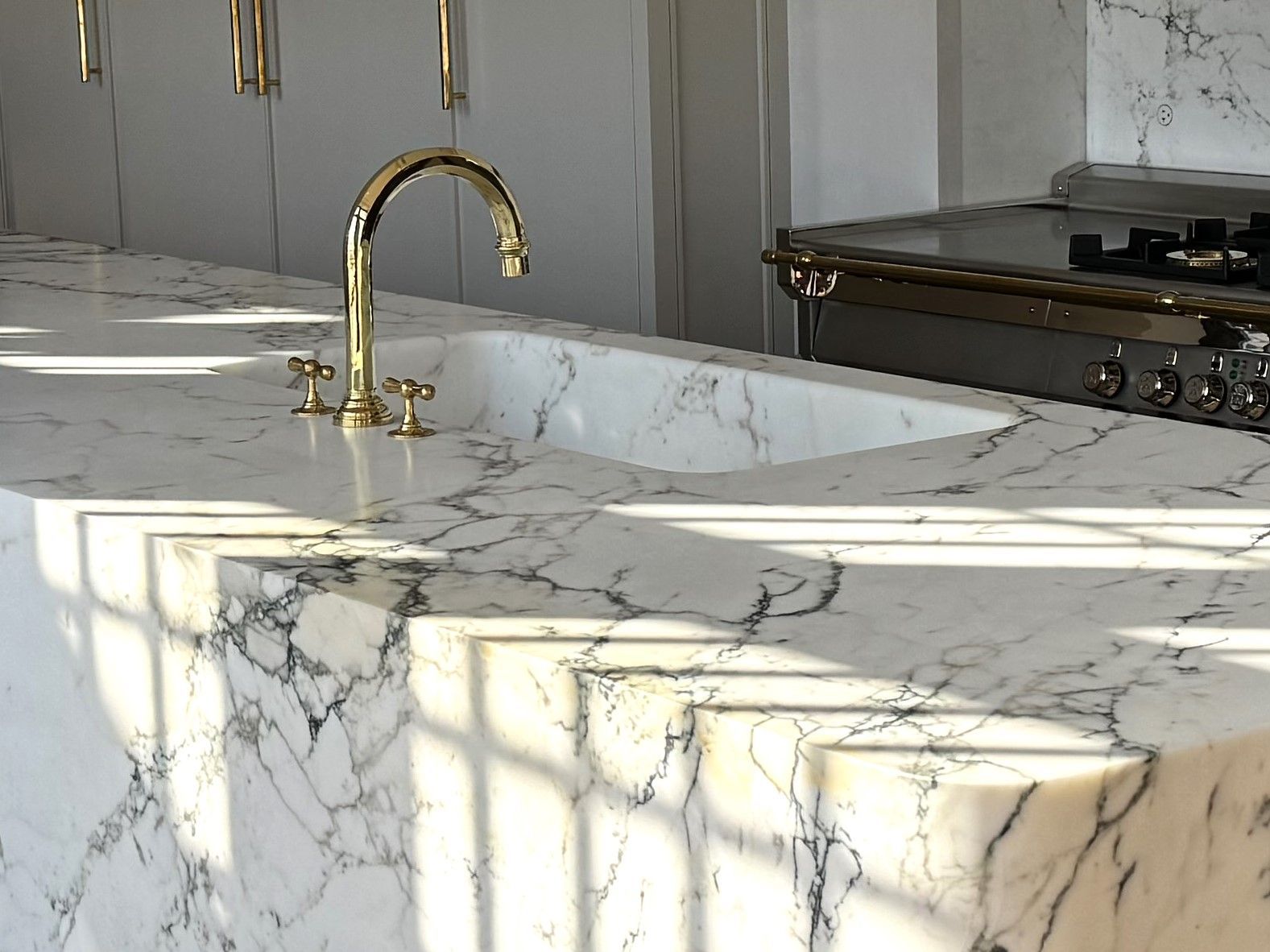 A kitchen with a marble counter top and a sink