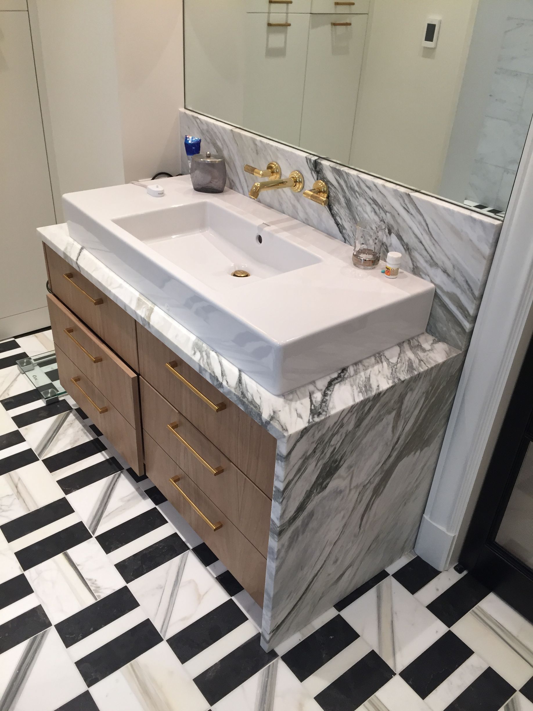 A bathroom with a black and white checkered floor and a sink