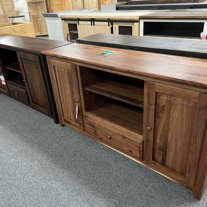 A row of wooden cabinets sitting on top of a carpeted floor in a store.