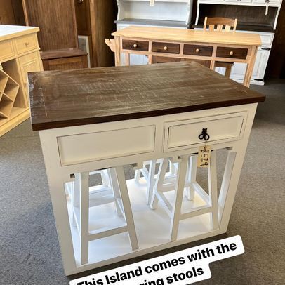 A kitchen island with stools and a wooden top in a store.