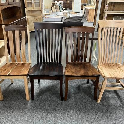 Three wooden chairs are sitting next to each other in a room.