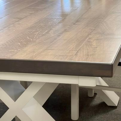 A table with a wooden top and white legs is sitting on a carpet.