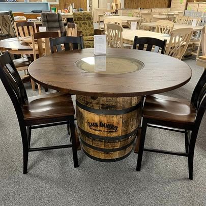 A round table made out of a whiskey barrel with four chairs.
