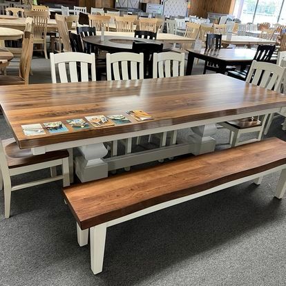 A wooden table with a bench and chairs in a room.