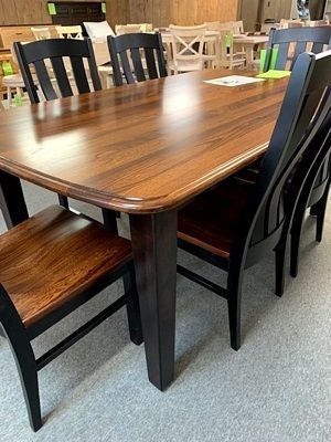 A wooden dining table with black chairs in a room.