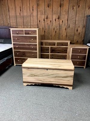 A bedroom with a dresser , chest of drawers , nightstand , and coffee table.