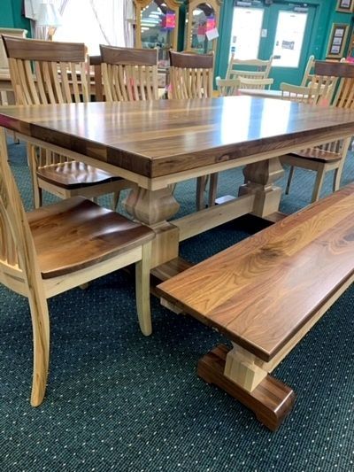 A wooden table with chairs and a bench in a room.