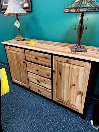 A wooden cabinet with drawers and a lamp on top of it