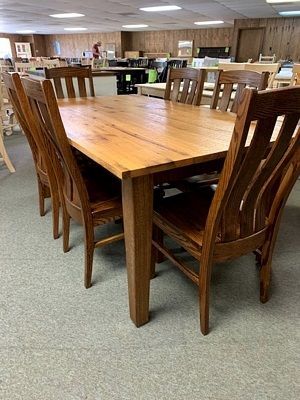 A wooden table and chairs are sitting in a room.