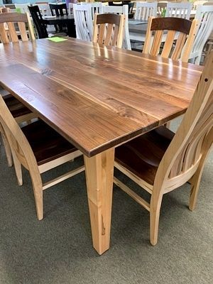 A wooden table and chairs are sitting on top of a carpeted floor.