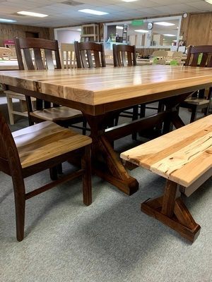 A wooden table with chairs and a bench in a room.