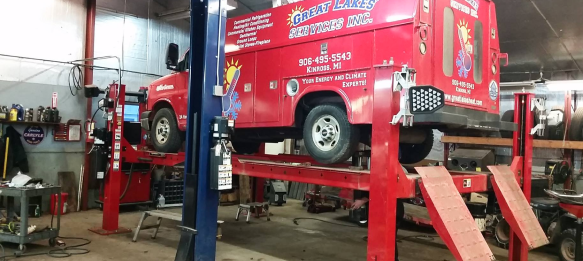 A Red Truck on a Lift at Tri-County Motors in Rudyard, MI