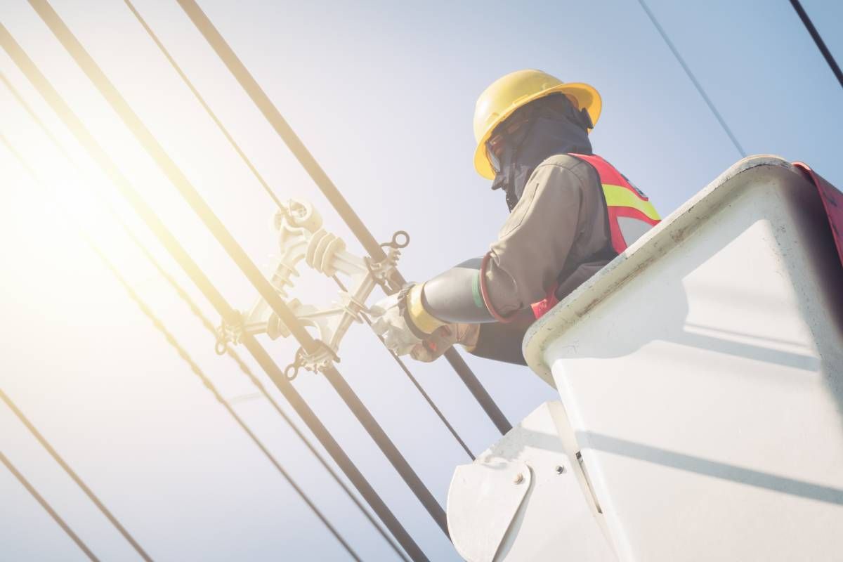 A cable tech working on infrastructure while in a bucket truck and wearing safety gear at Walker Electric near Lexington, KY