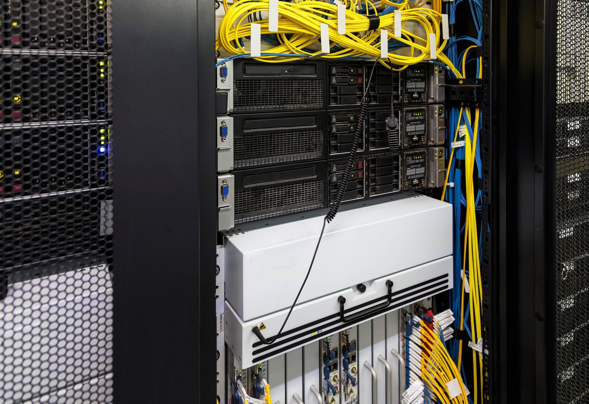 A data center with tidy yellow and blue cable management, keeping the communication services organiz