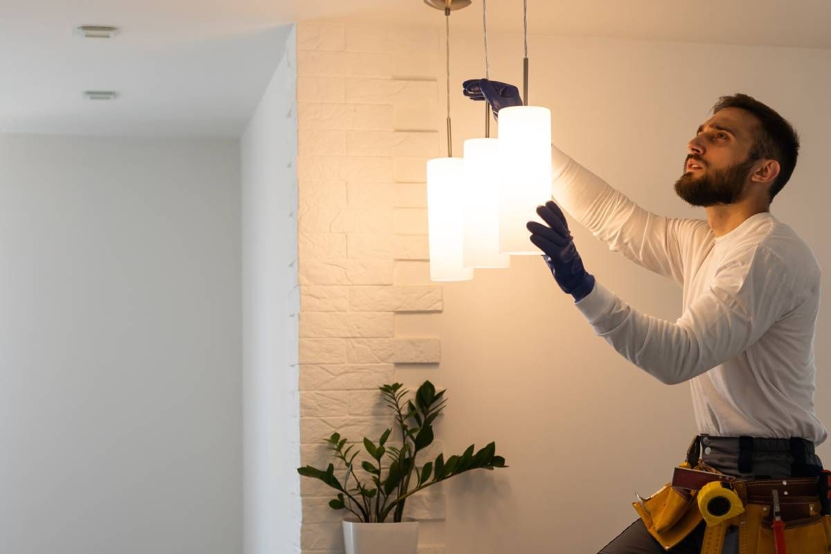 A commercial electrician working to install new light fixtures for a new business space at Walker Electric near Lexington, KY